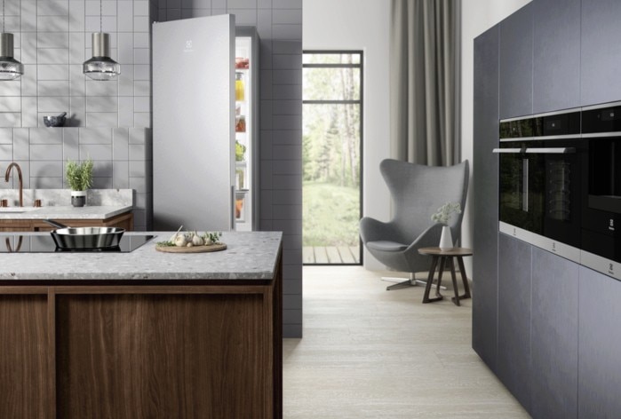 Modern kitchen with built-in ovens and an open fridge.